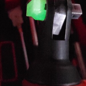 May include: A black and silver socket wrench with a green plastic release button. The wrench is designed for use with a variety of sockets.