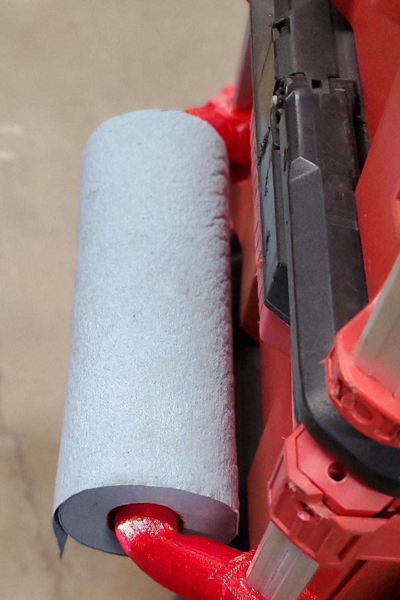 Puede incluir: Una caja de herramientas roja y negra con un asa de espuma gris. El asa est&aacute; unida a la caja con un soporte de metal rojo.