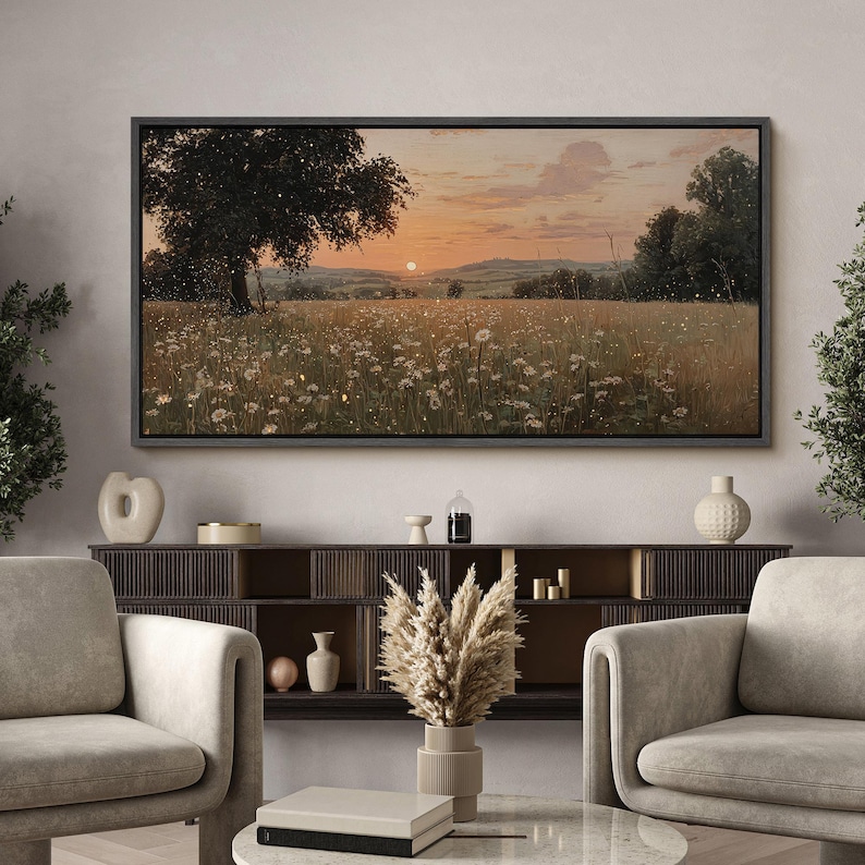 Puede incluir: Una impresi&oacute;n de arte mural rectangular de paisaje que muestra un atardecer sobre un campo de flores silvestres blancas y hierba alta, con un &aacute;rbol grande a la izquierda y colinas en la distancia, enmarcada con un borde negro fino en la pared.