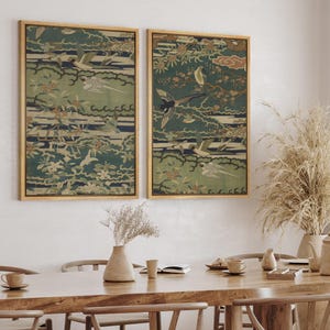 May include: Two rectangular wall art prints in light wood frames featuring a dark green background with a repeating pattern of flying birds, stylized clouds, and floral branches in shades of cream, blue, and muted orange, displayed side by side.
