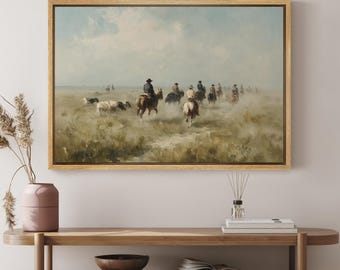 May include: A framed landscape painting depicting a group of riders on horseback moving across a dusty, open field under a pale, overcast sky. The scene features muted earth tones, including shades of brown, tan, and soft blue, capturing a wide, expansive view of a rural prairie setting.