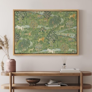 May include: A framed tapestry with a detailed landscape scene. The artwork features a green background with trees, animals, and a flowing river. Lions, deer, and white horses are depicted in the pastoral setting. The frame is a light brown color.