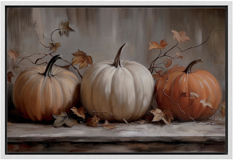 May include: A framed painting featuring three pumpkins in shades of orange and white. The pumpkins are arranged on a wooden surface, with dried leaves and vines adding to the autumn theme. The background is a muted gray.