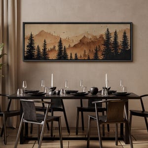 May include: A dining room scene featuring a long, black table set for a meal. Above the table hangs a framed landscape painting of a mountain range and pine trees in shades of brown. The table is set with black plates, glasses, and candles.