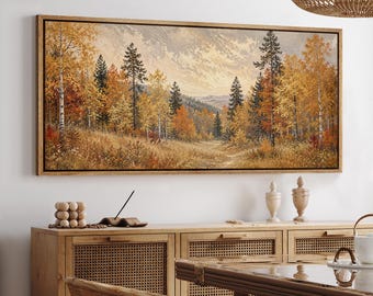 May include: A rectangular landscape painting in a wooden frame depicting a forest scene during autumn. The artwork features tall evergreen and deciduous trees with golden, orange, and brown foliage set against a backdrop of distant mountains.