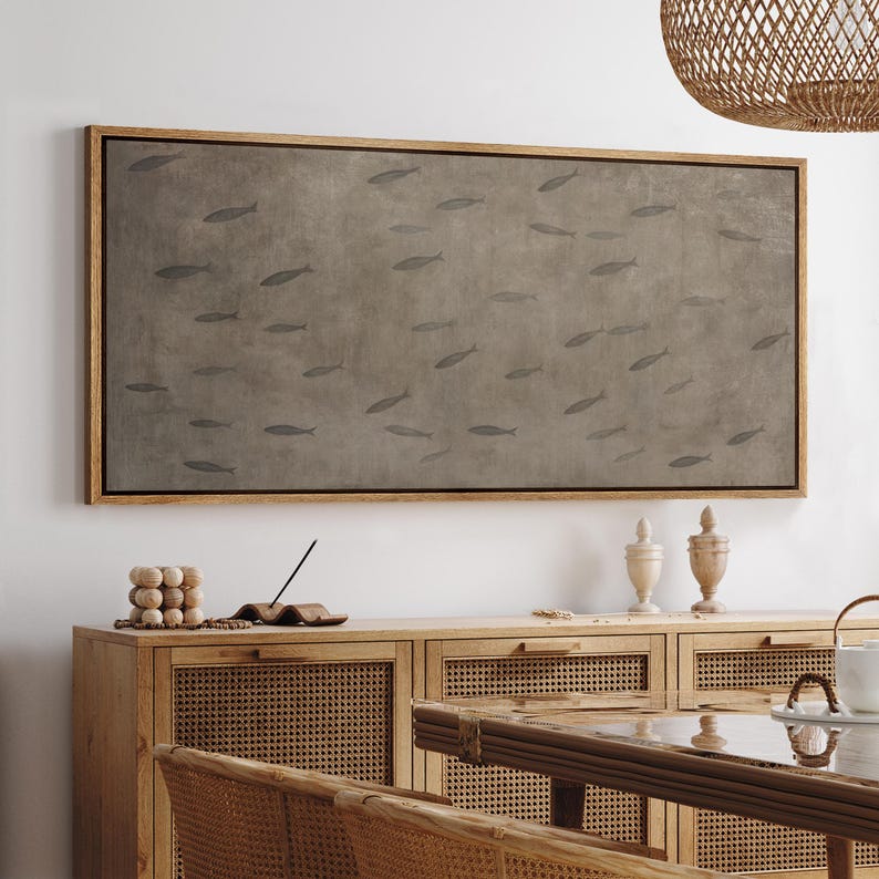Puede incluir: Una obra de arte enmarcada que representa un banco de peces nadando sobre un fondo gris-marr&oacute;n apagado. La obra est&aacute; encerrada en un marco de madera natural. El dise&ntilde;o minimalista evoca una sensaci&oacute;n de calma y serenidad.