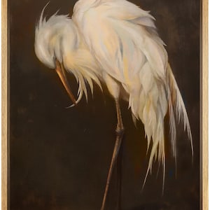 May include: A framed painting of a white egret with its head tucked down, showcasing its long beak and delicate feathers. The bird's legs are thin and brown, set against a dark brown background. The artwork is in a wooden frame.