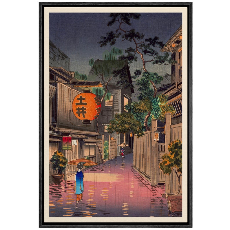 May include: A Japanese woodblock print depicting a rainy night scene in a narrow street lined with traditional buildings. A woman with an umbrella walks in the street, and a lantern with the Japanese characters "吉井" hangs above a shop.
