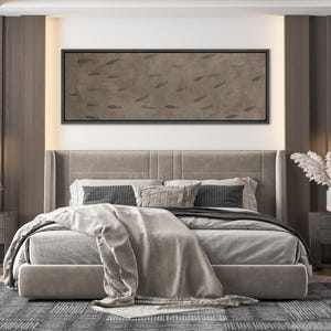 Puede incluir: Escena de dormitorio con una cama grande, un cabecero tapizado gris y ropa de cama. Encima de la cama hay una obra de arte rectangular enmarcada con un patr&oacute;n de siluetas de peces. La habitaci&oacute;n tiene una paleta de colores neutros con detalles en madera y una alfombra estampada.