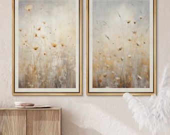 Puede incluir: Dos impresiones enmarcadas de una pintura de acuarela de un campo de flores silvestres en tonos beige, marrón y blanco. Las impresiones están en marcos de madera simples y naturales.