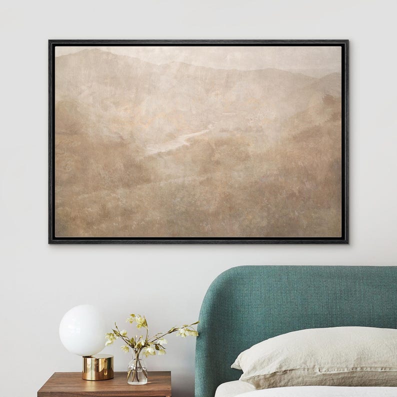 May include: A framed landscape art print featuring a muted, sepia-toned mountain range. The artwork has a textured appearance and is set within a black frame. The print evokes a sense of tranquility and natural beauty, suitable for home decor.