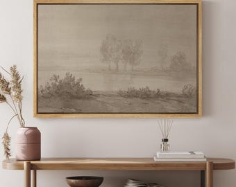 May include: A framed landscape painting with a muted color palette. The painting depicts a misty scene with trees and a lake in the background. The frame is a light wood color.
