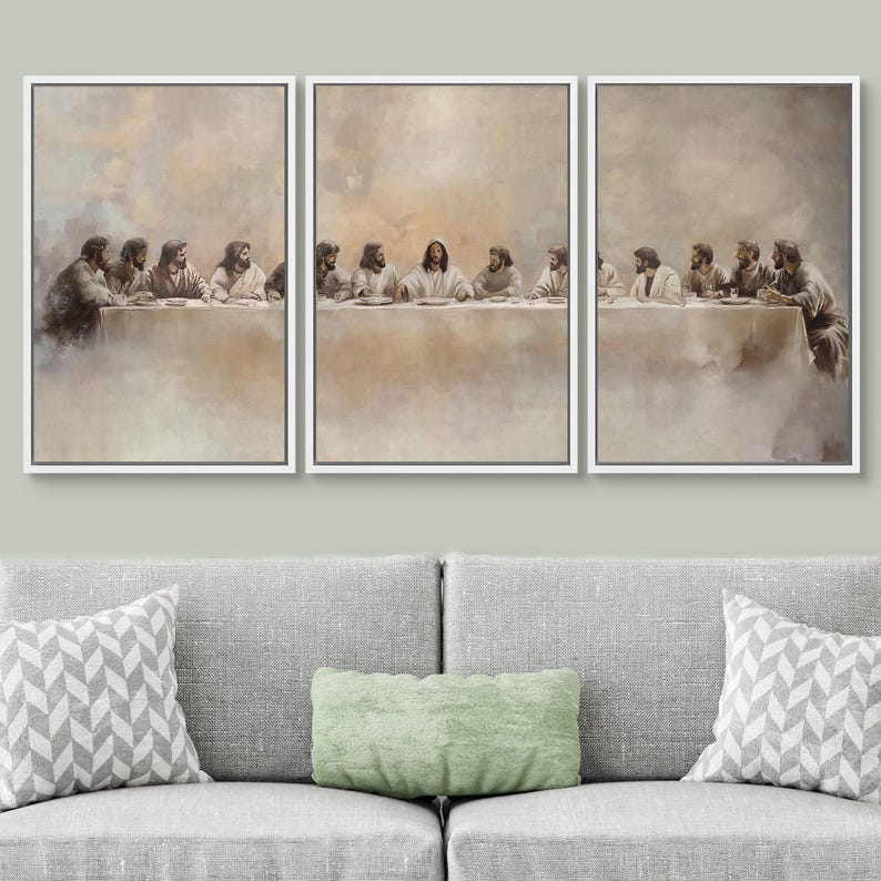 May include: A triptych canvas art print of the Last Supper. The artwork features a neutral colour palette with figures seated at a long table. Each framed panel is displayed above a grey sofa with decorative cushions.
