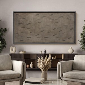 Puede incluir: Obra de arte rectangular enmarcada que representa un grupo de peces sobre un fondo marr&oacute;n. El lienzo con marco negro cuelga sobre un mueble de madera oscura y dos sillones beige. Ideal para el sal&oacute;n.