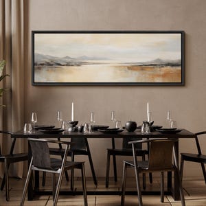 May include: A long, horizontal abstract landscape painting in a black frame hangs above a black dining table with six chairs. The painting features a muted color palette of beige, brown, and gray, depicting a lake with mountains in the distance.