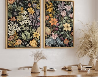 Op de afbeelding: Twee ingelijste bloemenprints met een donkere achtergrond en kleurrijke bloemen. De prints zijn in gouden lijsten en hangen aan een witte muur.