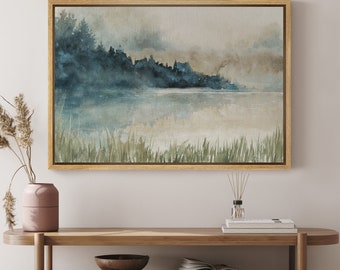 May include: A watercolor painting of a lake with a forest in the background. The painting is framed in a light wood frame and is hanging on a white wall.