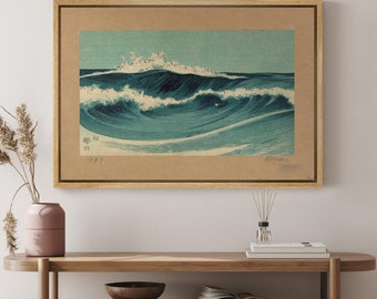 May include: A framed print of a Japanese woodblock print depicting a large wave crashing in the ocean. The wave is blue and white with a light blue sky in the background. The print is framed in a light wood frame.