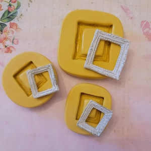 May include: Three yellow silicone molds for making resin picture frames. The molds are in the shape of a square with a slightly rounded edge. The frames are white and have a decorative design.
