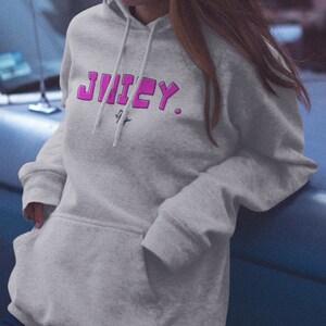May include: A gray hooded sweatshirt with the word "JUICY" printed in pink letters on the front.