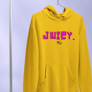 May include: A yellow hoodie with a pink "JUICY." logo and the number "94" written underneath.