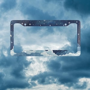 May include: A rectangular number plate frame featuring a dark navy blue night sky design with white twinkling stars and soft, light blue clouds along the bottom edge. The frame has four circular mounting holes, two at the top and two at the bottom.