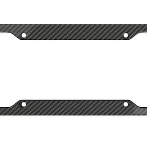 May include: A rectangular license plate frame with a carbon fiber weave pattern. The frame is dark gray and has four mounting holes. The design gives a modern, sporty look to any vehicle.