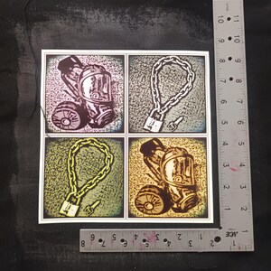 May include: A square print featuring four panels with illustrations. Two panels depict a gas mask, and the other two show a chain with a padlock and key. The artwork has a vintage, industrial aesthetic.