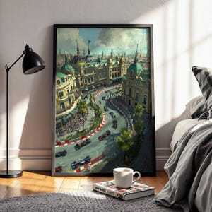 May include: A framed art print depicting a vintage race car competition in a European city. The artwork features a winding track, race cars, and buildings with green domes. A black lamp, a coffee cup, and a book are in the foreground.