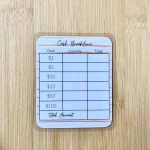 May include: A white cash breakdown tracker with pink and brown stripes. The tracker has columns for cash denominations, quantity, and total. The denominations are $1, $5, $10, $20, $50, and $100. The tracker also has a row for the total amount.