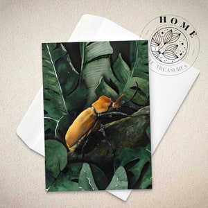 May include: A watercolor painting of a large, orange beetle perched on a branch surrounded by lush green leaves.