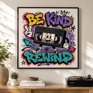 Peut inclure: Une impression murale carrée représentant un personnage de cassette VHS de dessin animé avec des bras et des jambes, faisant un signe de paix. Le fond présente des graffitis de mur en briques violettes, des éclaboussures de peinture rose et bleu sarcelle, et le texte BE KIND REWIND en lettres grasses.