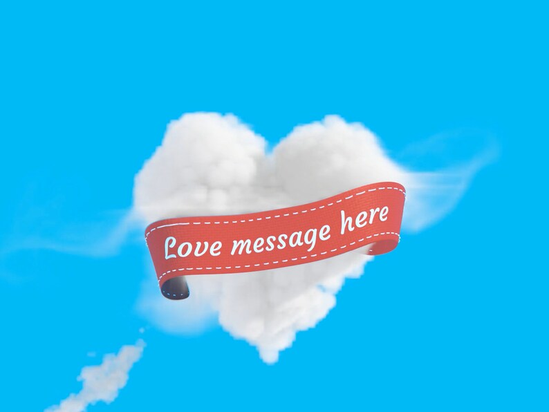 Puede incluir: Una nube con forma de coraz&oacute;n con una cinta roja que dice "Love message here" contra un cielo azul.
