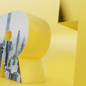 May include: Yellow 3D letters spelling "YOUR" with a cityscape image inside the letter "R".