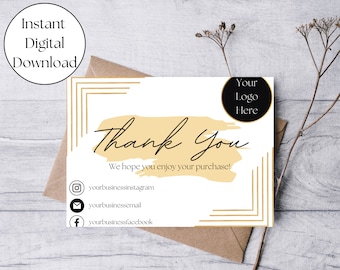 May include: A white thank you card with a gold brushstroke design and the text "Thank You". The card also includes the text "We hope you enjoy your purchase!" and social media icons with the text "yourbusinessinstagram", "yourbusinessemail", and "yourbusinessfacebook".