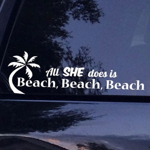 Puede incluir: Calcomanía de vinilo blanco con una palmera y el texto "All SHE does is Beach, Beach, Beach".