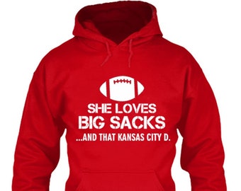 May include: Red hoodie with a white football graphic and the text "She loves big sacks...and that Kansas City D."