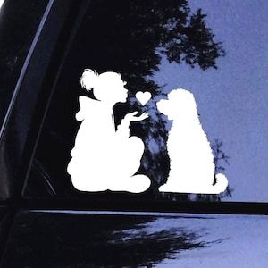 Naklejka na szybę samochodu Goldendoodle – Siedząca kobieta w kapturze kocha swojego Goldendoodle. Goldendoodle – Całujące się serca, psia mama – winylowa naklejka na szybę samochodu