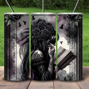May include: A set of three stainless steel tumblers with a black and white design featuring a woman with long black hair reading a book. The design also includes black roses, birds, and a watercolor background.