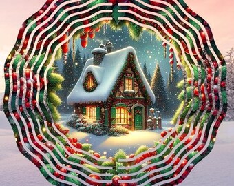 Peut inclure: Ornement de Noël en métal représentant un chalet enneigé. Le chalet a des volets et une porte verts, ornés d'une guirlande et de lumières. L'ornement est encadré par un design en couches avec des baies rouges, des feuilles vertes et des lignes blanches.