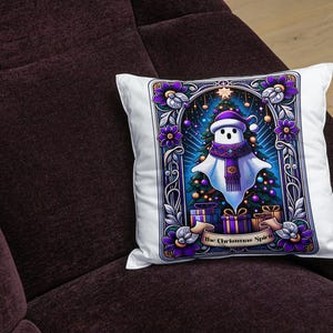 May include: A white throw pillow with a colorful illustration of a ghost wearing a purple scarf and a Santa hat. The ghost is standing in front of a Christmas tree with presents underneath. The text "The Christmas Spirit" is at the bottom of the illustration.