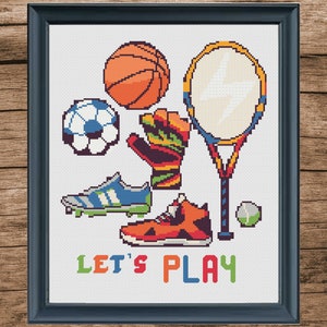 May include: Cross stitch pattern featuring a colorful illustration of various sports equipment, including a basketball, soccer ball, tennis racket, baseball, running shoes, and soccer cleats. The text "LET'S PLAY" is written below the sports equipment.