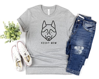 Puede incluir: Una camiseta gris con un contorno negro de la cabeza de un husky y el texto "Husky Mom".