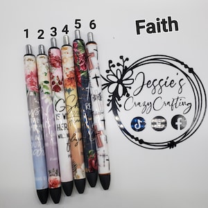 May include: Six ballpoint pens with floral and cross designs. The pens feature various colors, including pink, purple, and blue, with inspirational text. The pens are numbered 1 through 6 and are set against a white background. The word "Faith" is also visible.