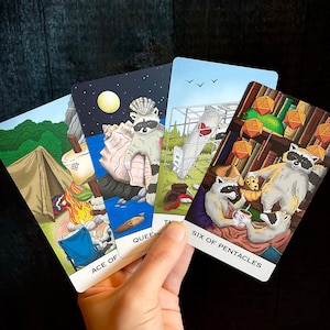 Op de afbeelding: Vijf tarotkaarten met kleurrijke illustraties. De kaarten zijn: Aas van Bekers, Koningin van Bekers, Zes van Pentakels, De Wereld en De Kluizenaar. De kaarten liggen in een waaier.