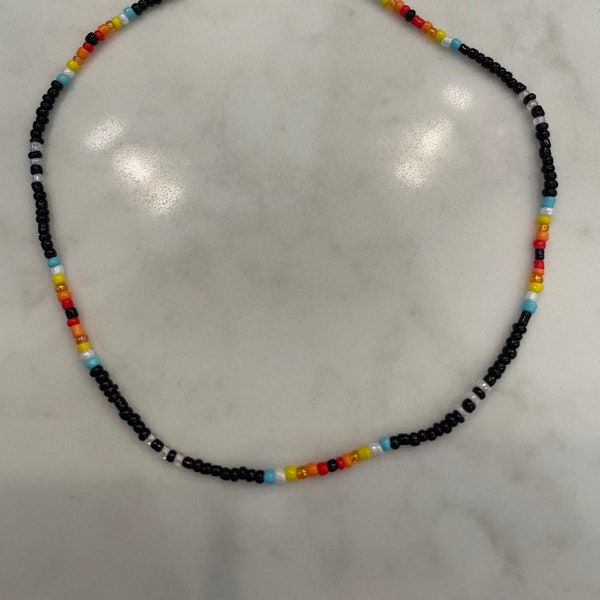 13” Black seed bead choker with quartz stone closure and red,orange,yellow,blue and clear beaded pattern