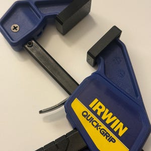 May include: Two blue and black Irwin Quick-Grip clamps. The clamps have blue handles with a yellow and black label that reads "IRWIN QUICK-GRIP". The clamps are made of plastic and metal and are designed for woodworking and other projects.