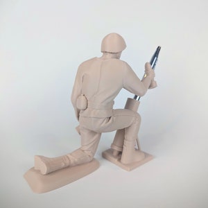 Peut inclure: Une figurine en plastique beige d'un soldat agenouill&eacute; et utilisant un mortier. Le soldat porte un casque et a une poche sur sa ceinture. Le mortier est en plastique argent&eacute; et a une base noire.