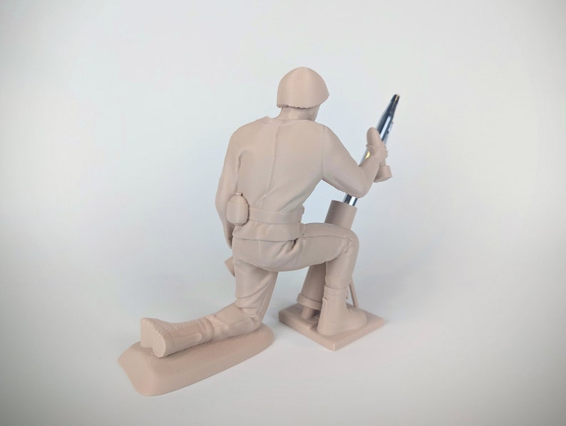 Peut inclure: Une figurine en plastique beige d'un soldat agenouill&eacute; et utilisant un mortier. Le soldat porte un casque et a une poche sur sa ceinture. Le mortier est en plastique argent&eacute; et a une base noire.