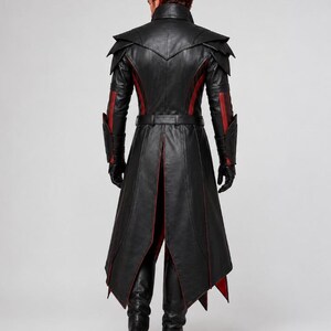 May include: A long black leather coat featuring red accents, a high collar, layered shoulder panels, and a belted waist. The coat has long sleeves with forearm guards, a split back hem, and is paired with black leather gloves and black boots.
